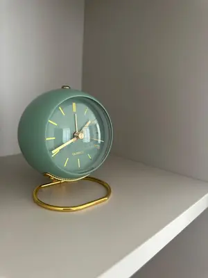 a green clock sitting on a table at Apartment Luxe Corner BW in Belgrade