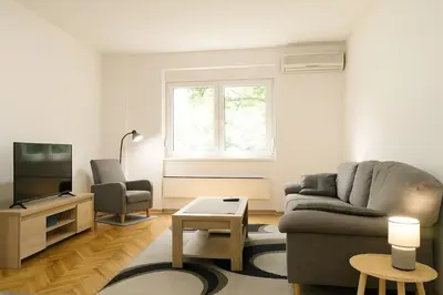 a living room with a couch and a tv at Cozy Stay 2 Min from Saint Sava Temple in Belgrade