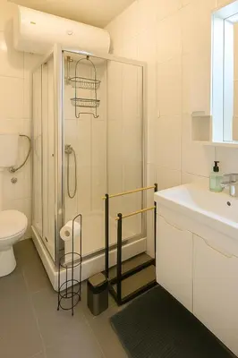 a bathroom with a shower and a toilet and a sink at Cozy Stay 2 Min from Saint Sava Temple in Belgrade