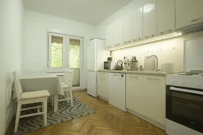 a kitchen with white cabinets and a table and a window at Cozy Stay 2 Min from Saint Sava Temple in Belgrade