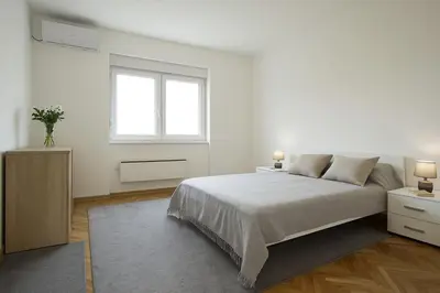 a white bedroom with a bed and a window at Cozy Stay 2 Min from Saint Sava Temple in Belgrade