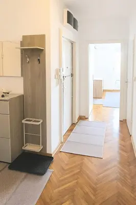 a living room with a wooden floor and white walls at Cozy Stay 2 Min from Saint Sava Temple in Belgrade