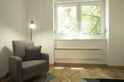 a living room with a chair and a window at Cozy Stay 2 Min from Saint Sava Temple in Belgrade