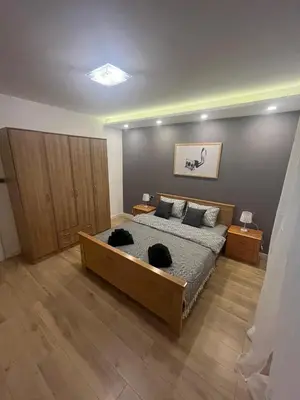 a bedroom with a large bed and wooden floors at Sava square apartment in Belgrade