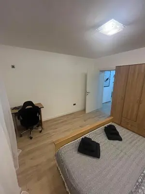 a bedroom with a bed and a desk and a chair at Sava square apartment in Belgrade