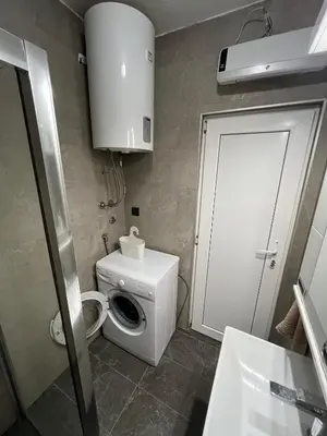 a small bathroom with a toilet and a door at Sava square apartment in Belgrade