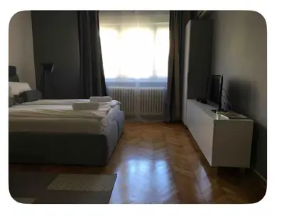 a bedroom with two beds and a television and a window at Pedestrian Zone Escape in Belgrade