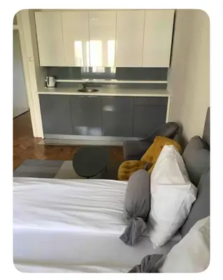 a bedroom with a white bed and a table at Pedestrian Zone Escape in Belgrade