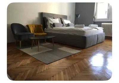 a bedroom with a bed and a chair and a table at Pedestrian Zone Escape in Belgrade