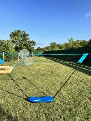 a person holding a tennis racket on a tennis court at 3A vikendica Slankamen in Stari Slankamen