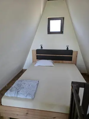 a bedroom with a bed in the attic at 3A vikendica Slankamen in Stari Slankamen
