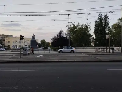 a white car driving down a street with a statue at Bulevar in Belgrade