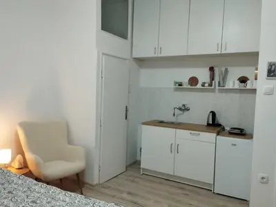 a white kitchen with a chair and a sink at Bulevar in Belgrade