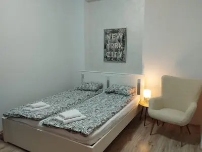 a bedroom with a bed and a chair and a lamp at Bulevar in Belgrade