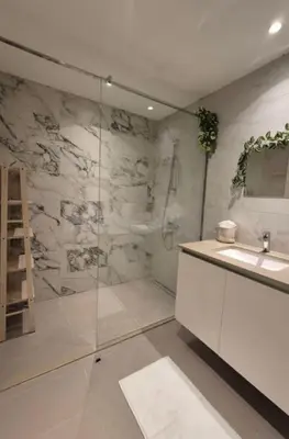 a bathroom with a glass shower and a sink at Apartment na vodi in Belgrade