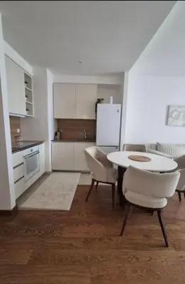 a kitchen with a table and chairs and a refrigerator at Apartment na vodi in Belgrade