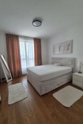 a bedroom with a large white bed and wood floors at Apartment na vodi in Belgrade