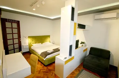 a bedroom with a bed and a chair in it at Studio Intriga in Belgrade
