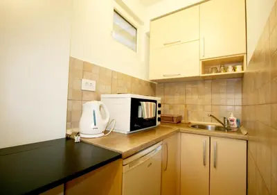 a small kitchen with a microwave and a sink at Studio Intriga in Belgrade