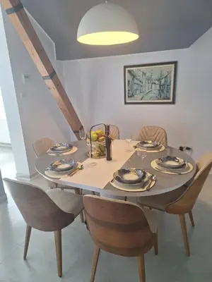a dining room with a table with chairs and a bowl of fruit at Iva Lux2 in Belgrade