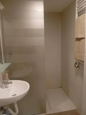 a bathroom with a sink and a glass shower door at Senjak studio apartment, near Belgrade fair in Belgrade
