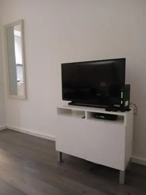 a flat screen tv sitting on a white entertainment center at Senjak studio apartment, near Belgrade fair in Belgrade