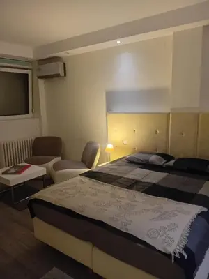 a hotel room with a large bed and a couch at Senjak studio apartment, near Belgrade fair in Belgrade