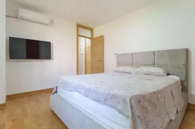 a white bedroom with a large bed and a flat screen tv at Premium STAN 70 in Fontana