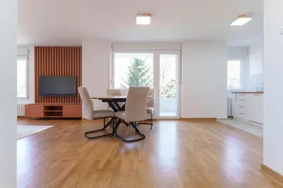 a living room with a table and chairs and a television at Premium STAN 70 in Fontana