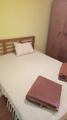 a bed with a towel sitting on top of it at Vikendica Mali Pozarevac