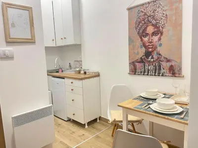 a kitchen with a table and a painting on the wall at Mignon - Belgrade's Secret in Belgrade