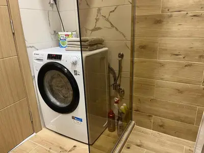 a washing machine in a bathroom with a shower at Mignon - Belgrade's Secret in Belgrade