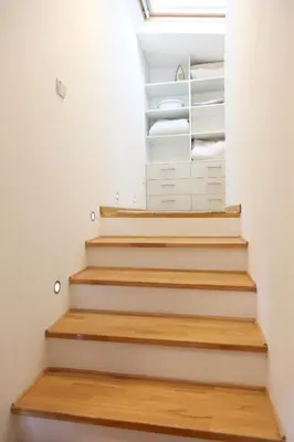 a staircase in a room with white walls and wooden floors at Purple and Green in Belgrade