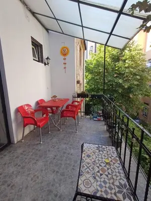 a patio with red chairs and a table on a balcony at Glorry L in Belgrade