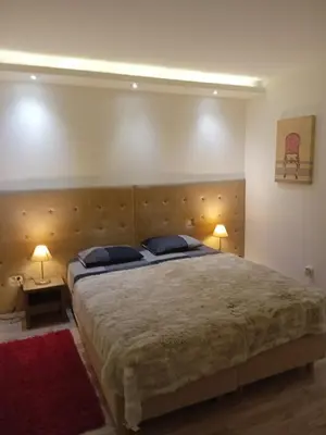 a bedroom with a large bed with two lamps at Senjak residence, apartment near Belgrade waterfront in Belgrade