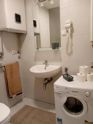 a bathroom with a washing machine and a sink at Senjak residence, apartment near Belgrade waterfront in Belgrade