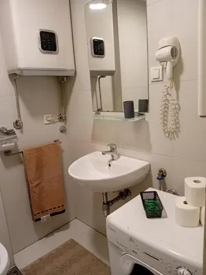 a white bathroom with a sink and a mirror at Senjak residence, apartment near Belgrade waterfront in Belgrade