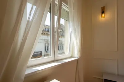 a window with a white curtain and a building at MONE 2 bedroom apartment in Belgrade