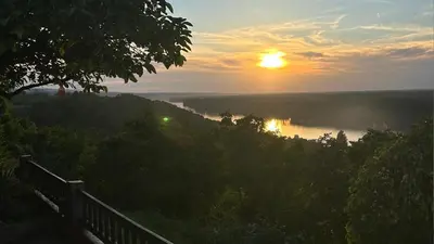 a sunset over a river with the sun in the sky at Panorama Beska in Beška
