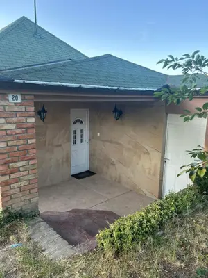 a garage with a white door and a brick building at Panorama Beska in Beška