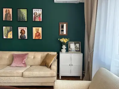 a living room with a couch and a green wall at Cozy aparts in the city heart in Belgrade