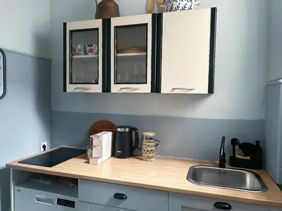 a kitchen with white cabinets and a sink at Cozy aparts in the city heart in Belgrade