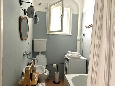 a bathroom with a toilet and a sink and a mirror at Cozy aparts in the city heart in Belgrade