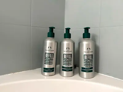 three shampoo bottles sitting on top of a sink at Cozy aparts in the city heart in Belgrade