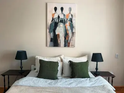 a bedroom with a bed with a painting above it at Cozy aparts in the city heart in Belgrade