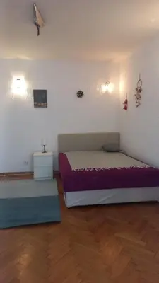 a bedroom with a large bed and a wooden floor at August in Belgrade