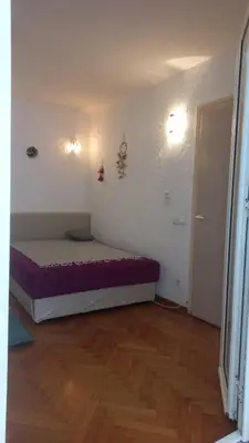 a bedroom with a bed in a room with a wooden floor at August in Belgrade