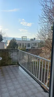 a balcony with a fence and a train in the distance at August in Belgrade