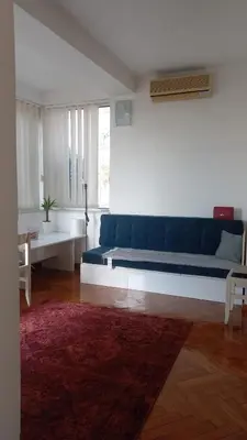 a living room with a blue couch and a red rug at August in Belgrade