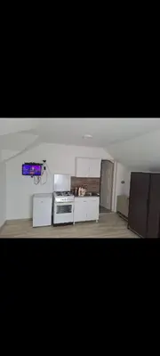 a kitchen with a stove and cabinets in a room at Apartmani Petrušić